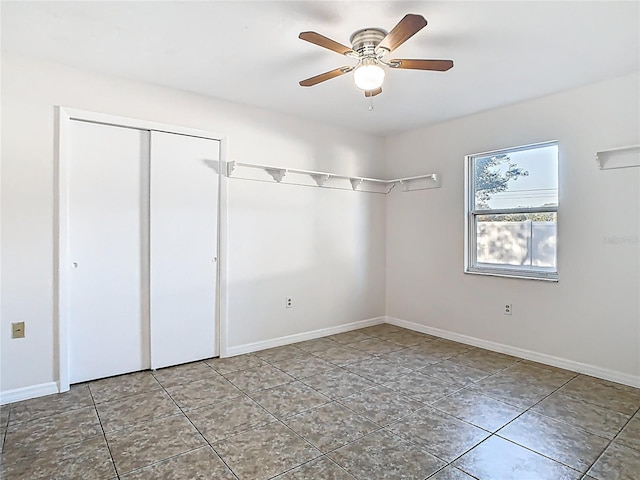 unfurnished bedroom featuring a closet, tile patterned flooring, ceiling fan, and baseboards