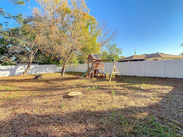 view of yard featuring a playground and a fenced backyard