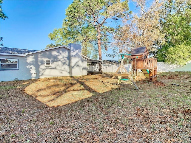 view of yard with fence and a playground