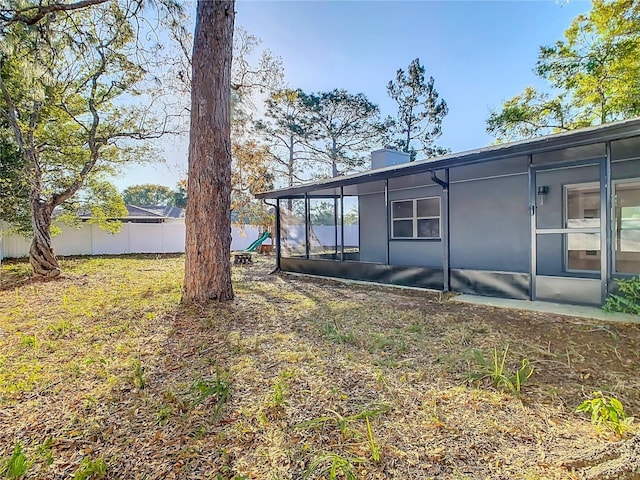 view of yard featuring fence and a sunroom