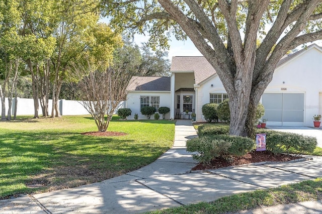 single story home with stucco siding, driveway, fence, a front yard, and a garage