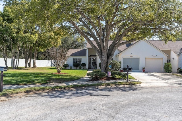 single story home with stucco siding, fence, concrete driveway, a front yard, and a garage