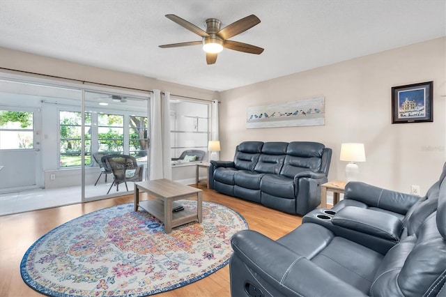 living room with wood finished floors, a textured ceiling, and ceiling fan