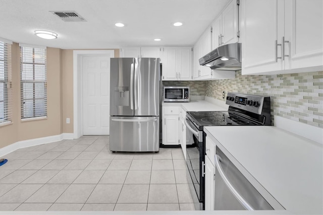 kitchen featuring light tile patterned floors, stainless steel appliances, light countertops, under cabinet range hood, and tasteful backsplash