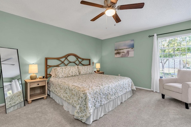 carpeted bedroom with baseboards, a textured ceiling, and ceiling fan