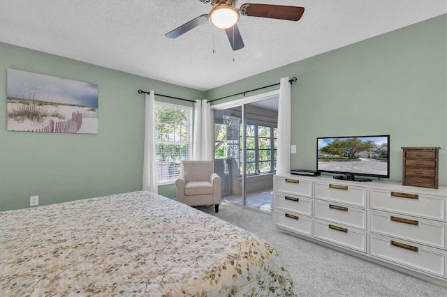 bedroom with a textured ceiling, ceiling fan, and light carpet