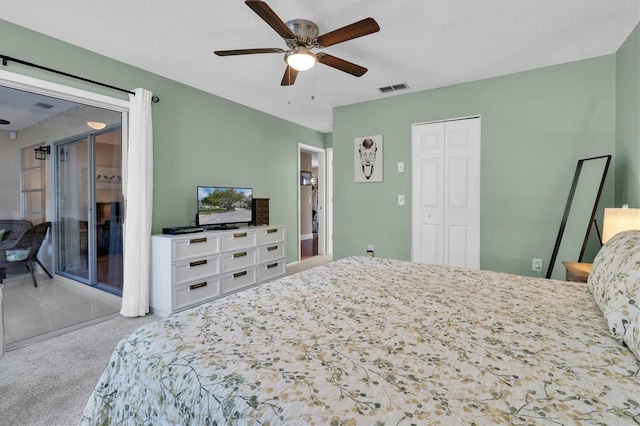 bedroom featuring visible vents, a textured ceiling, a closet, carpet, and ceiling fan