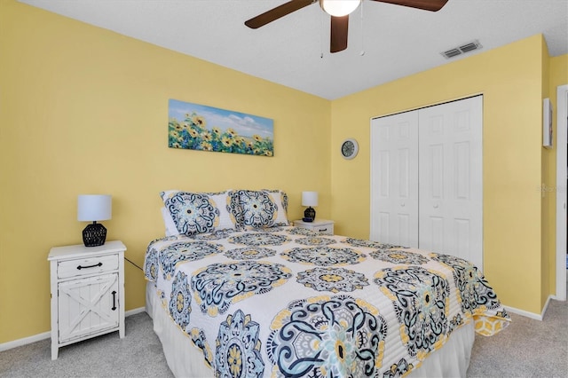 bedroom featuring a closet, visible vents, light colored carpet, and baseboards