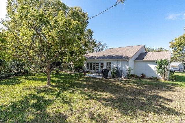 back of house featuring a patio area, central AC unit, stucco siding, and a lawn