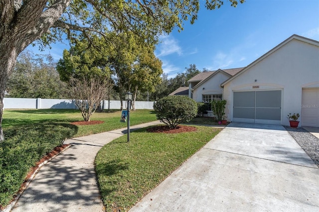 view of front of home featuring fence, driveway, an attached garage, stucco siding, and a front lawn