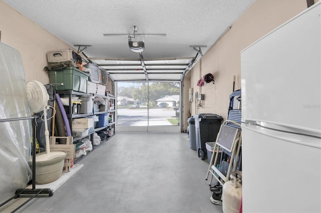 garage featuring a garage door opener and freestanding refrigerator