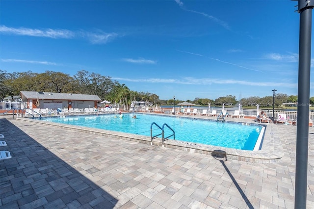 pool with a patio area and fence