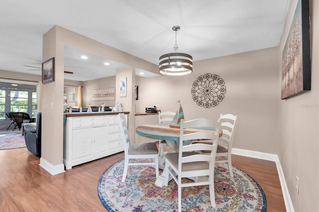 dining space with light wood finished floors, recessed lighting, an inviting chandelier, and baseboards