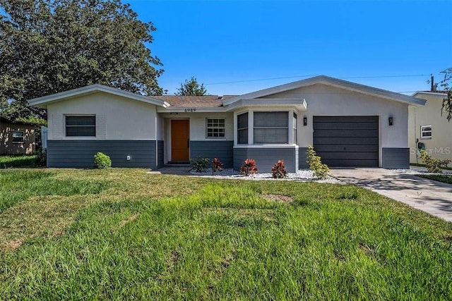 single story home featuring a front lawn, concrete driveway, and an attached garage