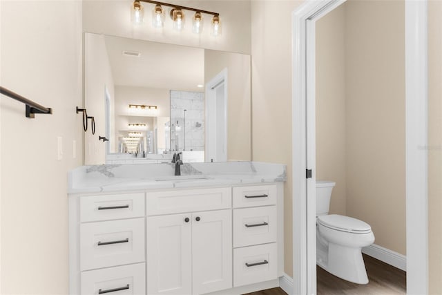 bathroom with visible vents, baseboards, toilet, a stall shower, and vanity