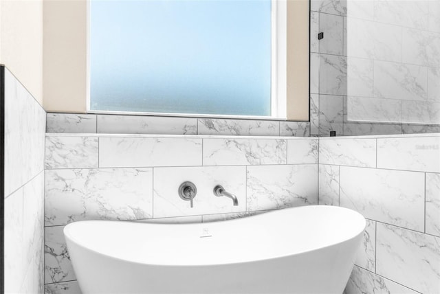 bathroom with a soaking tub and a healthy amount of sunlight