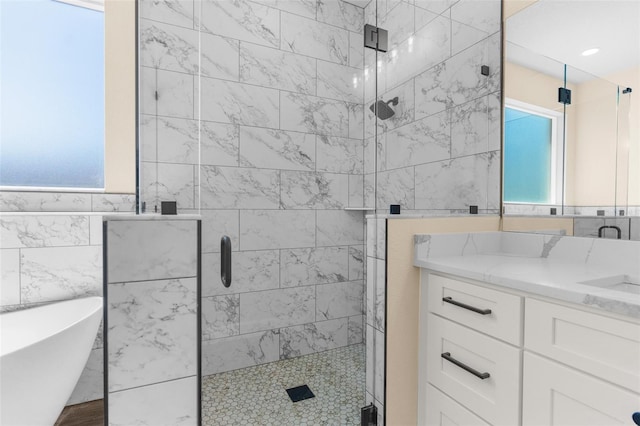 bathroom featuring vanity, tile walls, a stall shower, and a freestanding bath