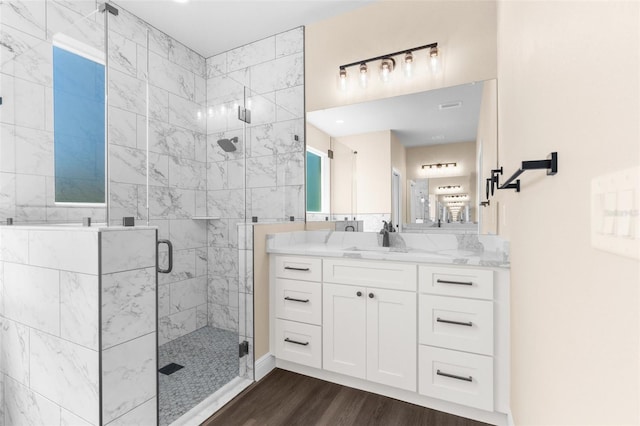 bathroom featuring vanity, wood finished floors, and a stall shower