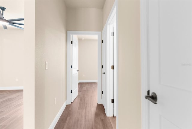 corridor featuring wood finished floors and baseboards