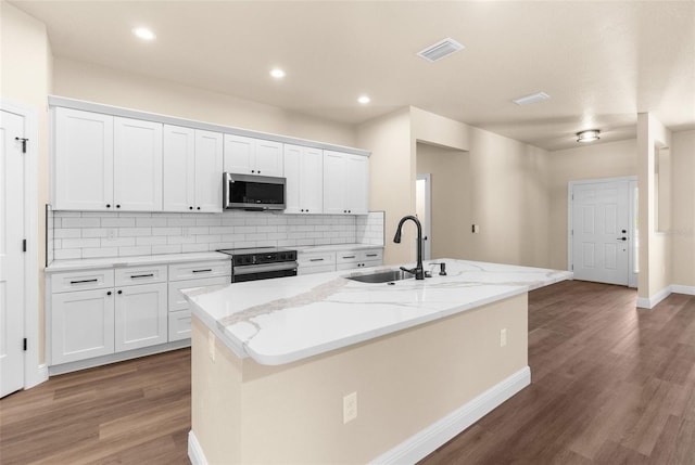 kitchen featuring a sink, stainless steel microwave, black range with electric stovetop, and white cabinets