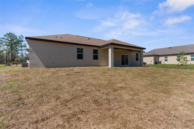 rear view of house with a yard and stucco siding