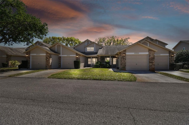 view of front of house featuring a yard, concrete driveway, and an attached garage