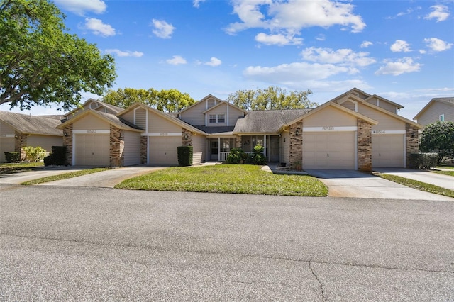 view of front of home with a garage, driveway, a shingled roof, and a front yard