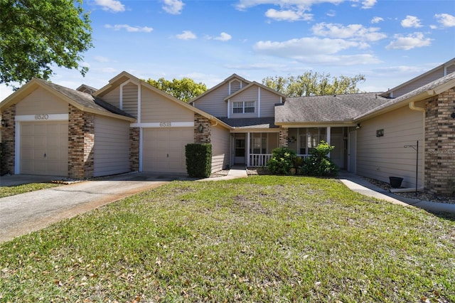 traditional-style home with driveway, a front lawn, an attached garage, a shingled roof, and brick siding