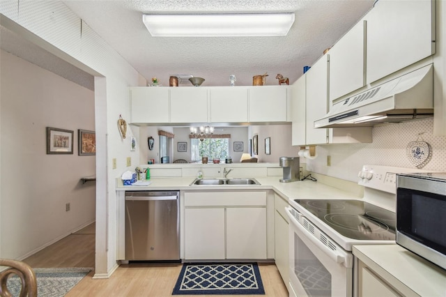 kitchen featuring a sink, under cabinet range hood, a textured ceiling, stainless steel appliances, and light countertops