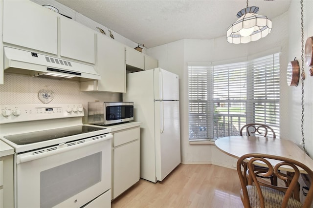 kitchen featuring under cabinet range hood, a textured ceiling, white appliances, light wood finished floors, and decorative backsplash