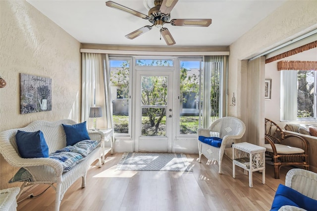 sunroom / solarium featuring a ceiling fan