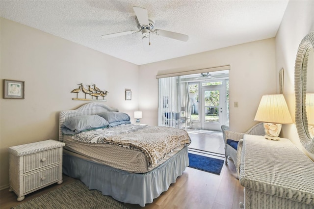 bedroom with a ceiling fan, access to exterior, wood finished floors, and a textured ceiling