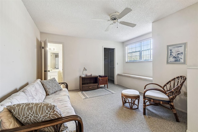 carpeted living area with a textured ceiling, baseboards, and a ceiling fan