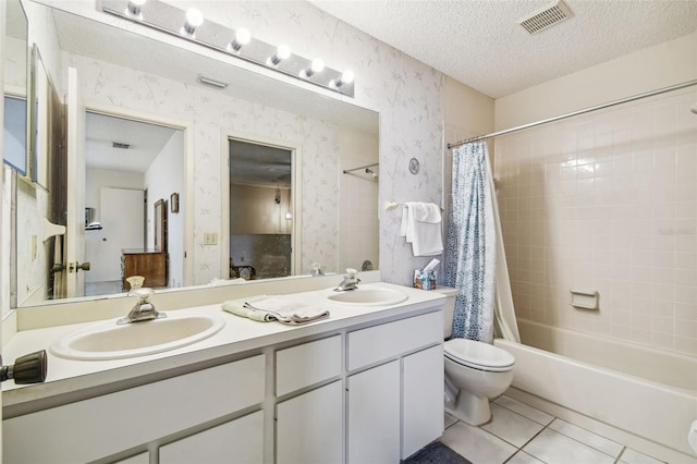 bathroom featuring visible vents, a sink, wallpapered walls, a textured ceiling, and tile patterned flooring