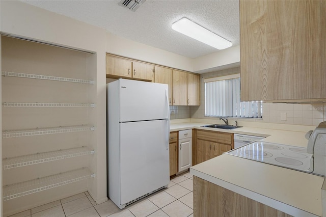 kitchen with visible vents, light brown cabinets, light tile patterned flooring, white appliances, and a sink