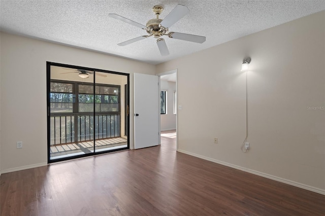 spare room with wood finished floors, baseboards, and a textured ceiling