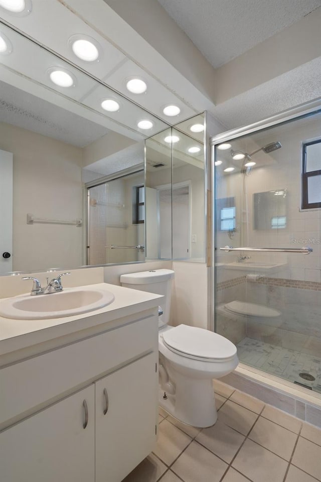 full bathroom featuring tile patterned flooring, a shower stall, toilet, and vanity