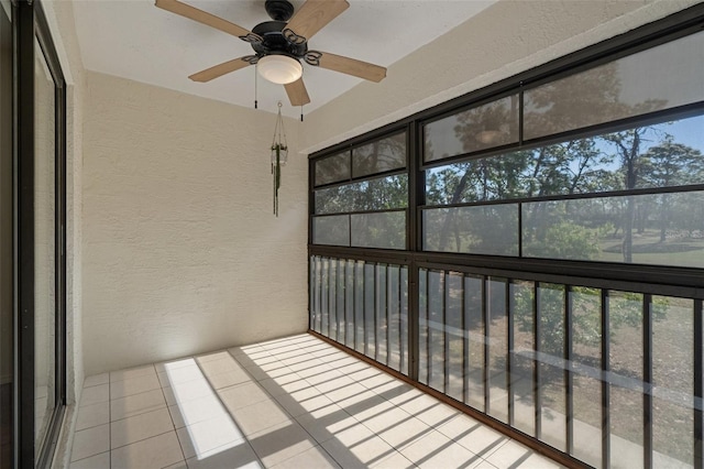 unfurnished sunroom with plenty of natural light and a ceiling fan