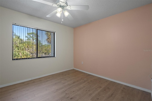 empty room with baseboards, light wood-style floors, ceiling fan, and a textured ceiling