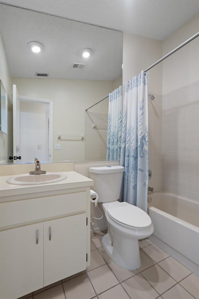 bathroom featuring tile patterned flooring, toilet, shower / tub combo with curtain, and a textured ceiling