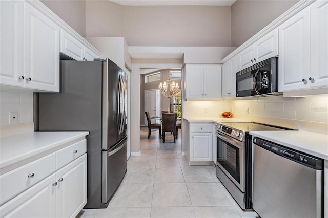 kitchen featuring a notable chandelier, stainless steel appliances, and decorative backsplash