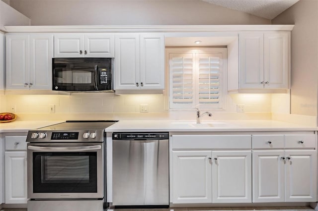 kitchen with a sink, lofted ceiling, appliances with stainless steel finishes, and white cabinetry