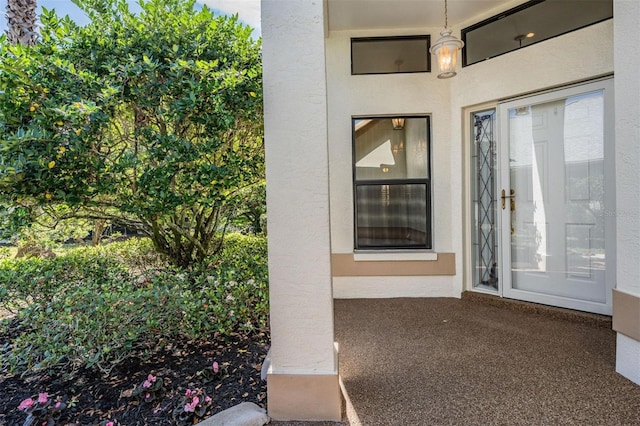 entrance to property featuring stucco siding