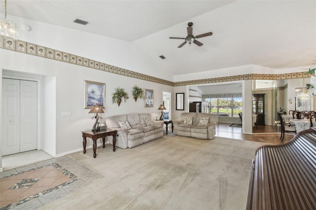 living area featuring visible vents, baseboards, ceiling fan, and vaulted ceiling