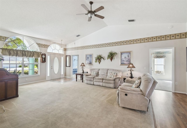 living room with visible vents, lofted ceiling, carpet floors, baseboards, and ceiling fan