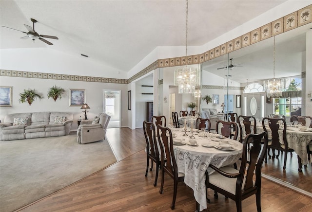 dining room with visible vents, ceiling fan with notable chandelier, high vaulted ceiling, and wood finished floors