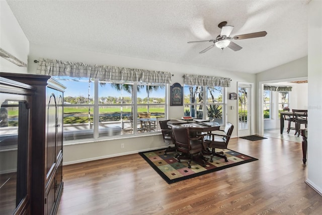 dining room featuring a textured ceiling, wood finished floors, ceiling fan, and vaulted ceiling