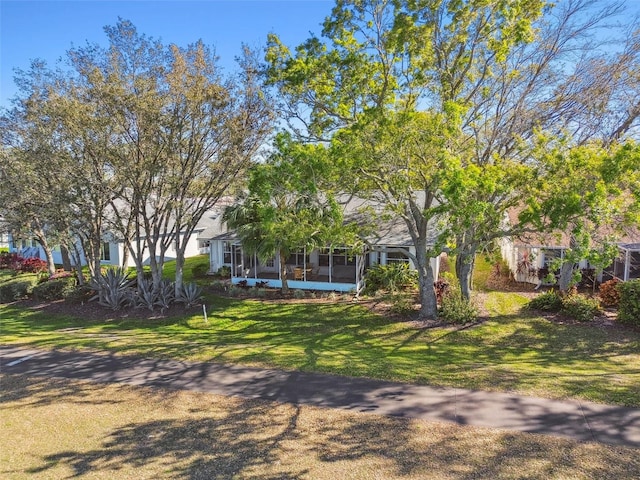 view of front facade featuring a front lawn and a sunroom