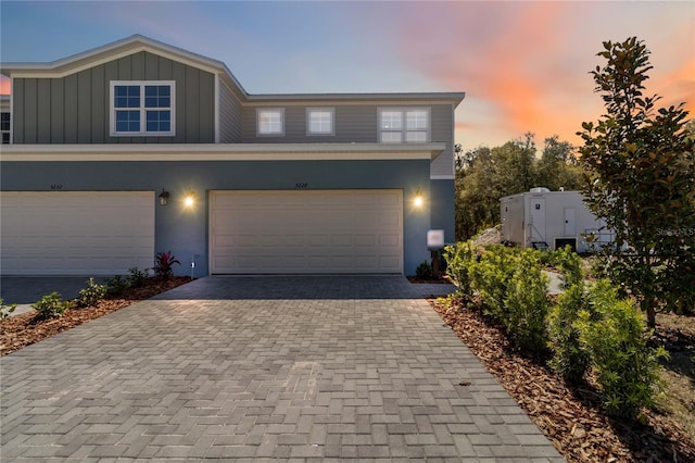 view of front of property with decorative driveway, board and batten siding, and stucco siding