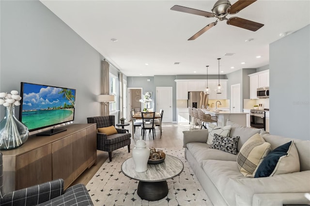 living room featuring light wood finished floors, recessed lighting, and a ceiling fan